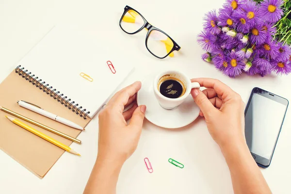 Жінка рукою з чашкою кави. Ранковий настрій з кавою, ноутбуком і телефоном. Дівчина планує день, нова ідея . — стокове фото