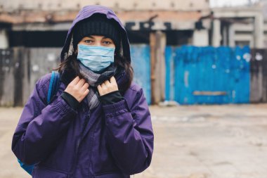 Coronavirus salgını ve karantina. Virüsü önlemek için hijyenik maske takan bir kadın. Hava kirliliği. Coronavirus salgını. Karantina şehrinde yüz maskesi olan biri. Kıyamet.