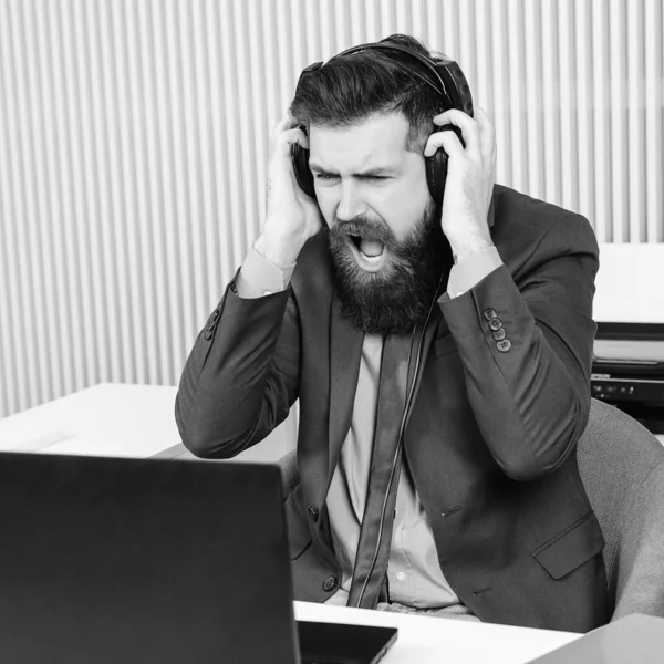 Gestresster Mann Büro Arbeitsplatz Mann Trägt Kopfhörer Schaut Auf Laptop — Stockfoto