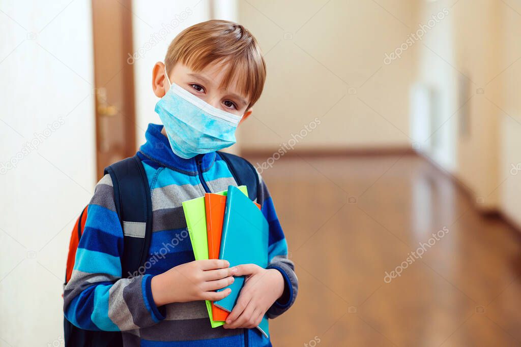 Schoolboy with protect mask on face. Face mask for protection coronavirus outbreak. Medicine healthcare mask. Coronavirus epidemic. Boy with protection mask. Kid in school. Coronavirus concept.