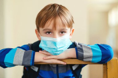 Okulda karantina var. Korunma maskeli bir öğrenci. Coronavirüs salgını. Koronavirüs salgını için yüz maskesi. Sağlık sigortası maskesi. Okuldaki çocuk. Coronavirus konsepti.