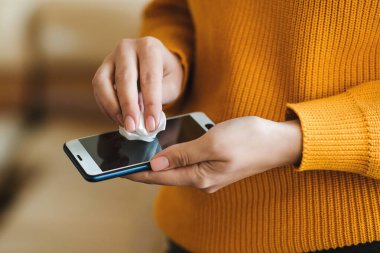 Coronavirus küresel salgını. Telefonu antiseptik ıslak mendille dezenfekte eden kadın. Coronavirus önleme. Kamu alanından sonra koronavirüsü önle. Coronavirus karantinası.
