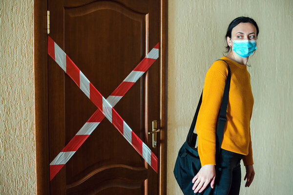 Карантин коронавируса. Закрытие офиса во время эпидемии коронавируса. Женщина в маске идет домой. Работа из дома во время коронавирусного карантина. Глобальная пандемия. Оставайтесь дома
.