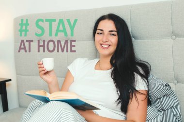 Genç bir kadın evde kendini soyutluyor. Coronavirus karantinası. Kadın evde kitap okuyor. Evde kal. Coronavirus önleme için sosyal medya kampanyası. Küresel salgın. Koronavirüsü durdurun..