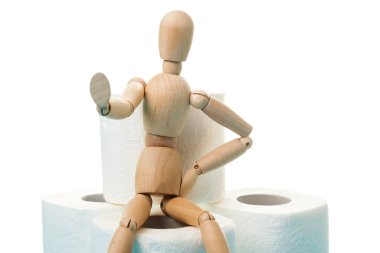 Tahta adam dur işareti gösteriyor. Coranovirüs salgını sırasında panik alışverişini durdurun. Coronavirus paniği 2020. Coronavirus ev karantinası. Tahta adam tuvalet kağıdı rulosunda oturuyor. İnsanlar panikler.