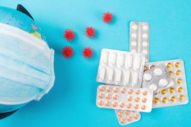 Coronavirus dünyaya yayıldı. Dünya küresi tıbbi maske ve haplarla dolu. Coronavirüs salgını. Küre ve ilaçlarla dolu bir geçmişi var. Üst görünüm, alanı kopyala.