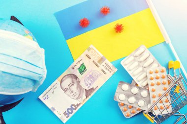 Ukrayna 'da Coronavirus salgını. Koruyucu ilaç konsepti. Koronavirüs salgını. Ukrayna parası ve mavi arka planda virüse karşı ilaç. Ukrayna 'da koronavirüsle savaşın. Coronavirus kuantini.