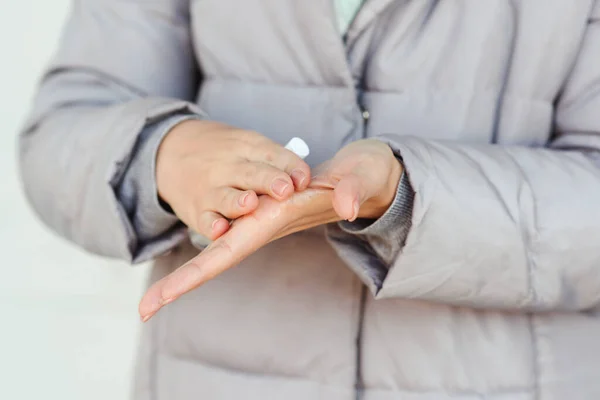 Coronavirus epidemic. Disinfecting hands outdoors. Global pandemic. Coronavirus spread protection. Woman using antiseptic spray for hands. Coronavirus prevention. Health care concept.