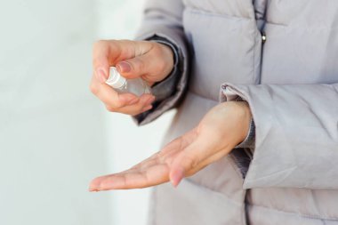 Dışarıda anti bakteriyel sprey kullanan bir kadın. Coronavirus 'a alkol spreyi sıkan kadın eller, yaklaşın. Mikropların, bakterilerin, koronavirüsün ve virüsün yayılmasını önlemek için antiseptik sprey. Antiseptik.