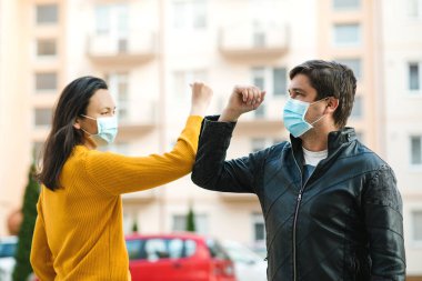 Arkadaşlar dışarıda dirseklerini sallıyor. İnsanlar virüsün yayılmasını önlemek için sosyal mesafeyi koruyorlar. Dirseklerle selamlaşan çift. Coronavirüs salgını. Coronavirus karantinası. Dünya çapında salgın.