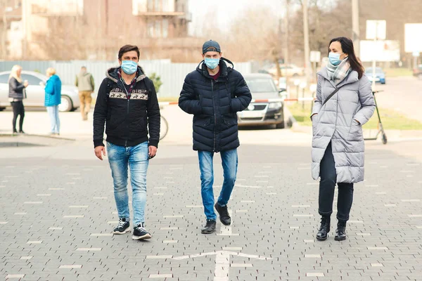 Coronavirus global pandemic. People in a medical mask outdoors. Coronavirus epidemic. People talking on street. Coronavirus quarantine. Friends wearing face mask. Covid-2019 outbreak.