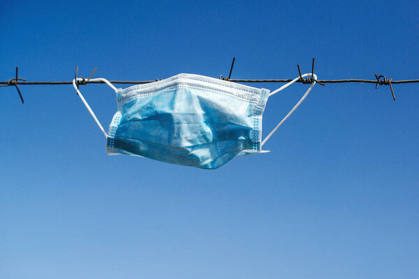 Колючая проволока и медицинская маска. Концепция борьбы с коронавирусом. Ограничения. Глобальная пандемия. Карантин коронавируса. Всемирная вспышка коронавируса. Меры ограничения предотвращают распространение вируса
.