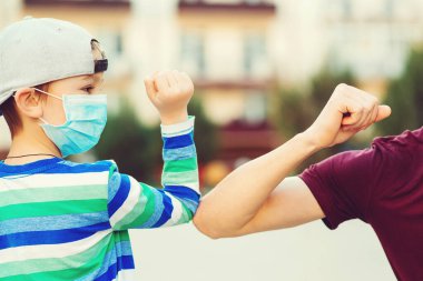 Dirseklerle aile selamlaşması. Coronavirus karantinası. Sosyal uzaklık kavramı. Aile, yaşam tarzı, yeni selamlaşma tarzı. Çocuk ve baba dışarıda dirsekleriyle selam veriyorlar. Coronavirus önleme.