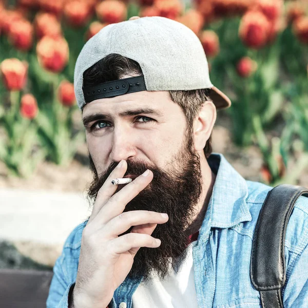 Bearded hipster smoking cigarette outdoors. Man thinking about something. Bearded worker has a break time. Smoking habit or addiction. Smoking addict or smoker. Hipster enjoy smoking break outdoors.