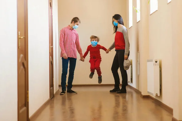 Family wearing face masks. Prevention coronavirus. Stay at home. Home quarantine. Coronavirus epidemic. Parents and kid wearing a surgical masks. Coronavirus outbreak. New real life.