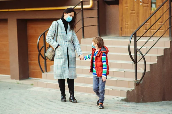 Family wearing face mask. Mother and son going to walk outdoors. Prevention coronavirus. Protective measures in public crowded place. Stop coronavirus. Coronavirus quarantine.