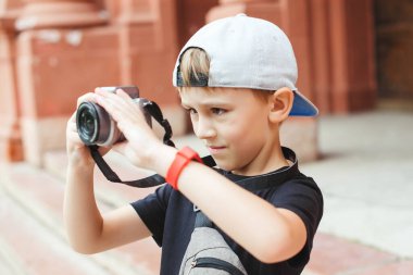 Şirin çocuk şehirde fotoğraf çekiyor. Yaz tatili için çocuklar için okul projesi. Geleceğin mesleği. Yaz tatilleri, anılar ve izlenimler. Fotoğrafçılar kulübü. Çocuk fotoğrafçı olmak istiyor..
