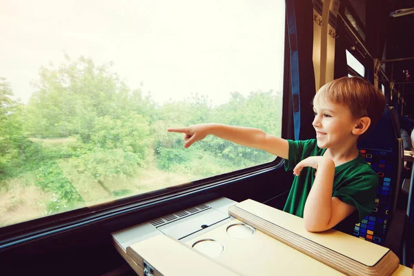 Cute boy traveling by train. Summer vacation. Little kid in a high speed express train on family vacation in Europe. Travel by railway. Children in rail way wagon.