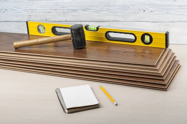 木工概念。不同的工具在新强化复合地板和笔记本、 铅笔。复制文本的空间. — 图库照片
