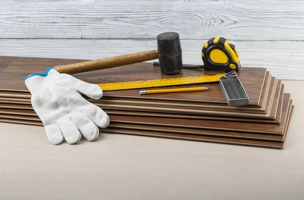 Carpentry concept. Different tools and gloves on the new laminate flooring.Copy space for text. — Stock Photo, Image