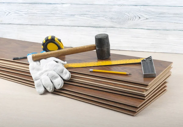 Carpentry concept. Different tools and gloves on the new laminate flooring.Copy space for text. — Stock Photo, Image