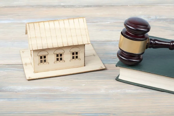 Concepto de ley. Modelo de casa con mazo de juez de madera en la mesa en una sala de tribunal u oficina de aplicación . — Foto de Stock
