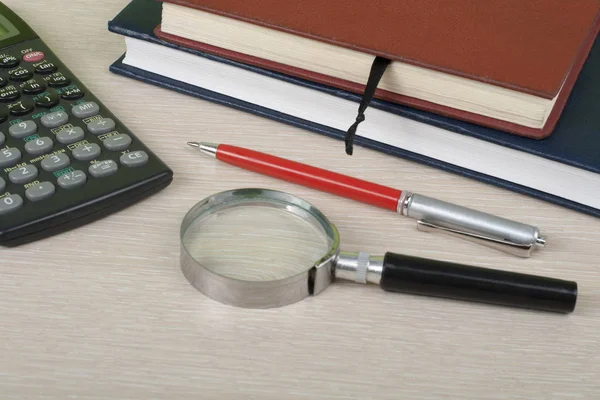 Σπίτι εξοικονόμηση, έννοια του προϋπολογισμού. Στυλό, Αριθμομηχανή, σημειωματάριο, μεγεθυντικό φακό σε ξύλινο γραφείο τραπέζι. — Φωτογραφία Αρχείου