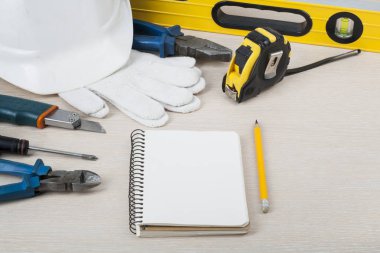 İnşaat araçları ve ahşap arka plan üzerinde beyaz kask. İnşaat kavramı.