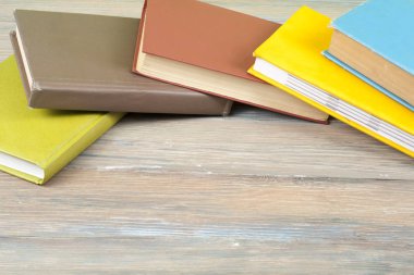 Ahşap masa, ücretsiz kopya alanı üzerinde renkli kitap yığını. Okula dönüş. Eğitim arka plan. Üstten Görünüm.