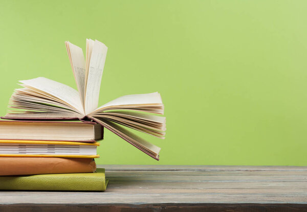 Open book, hardback books on wooden table. Education background. Back to school. Copy space for text.