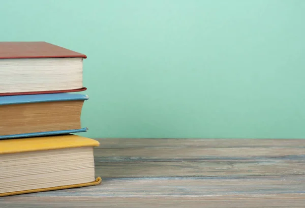 Ahşap masa, ücretsiz kopya alanı üzerinde renkli kitap yığını. Okula dönüş. Eğitim arka plan