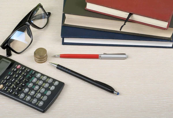 Σπίτι εξοικονόμηση, έννοια του προϋπολογισμού. Το σημειωματάριο, Αριθμομηχανή, μολύβι, γυαλιά και νομίσματα στο γραφείο τραπέζι. — Φωτογραφία Αρχείου