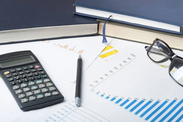 Binnenlandse besparingen, begroting concept. Grafiek, boekhouding, pen, rekenmachine en glazen op houten bureau tafel. — Stockfoto