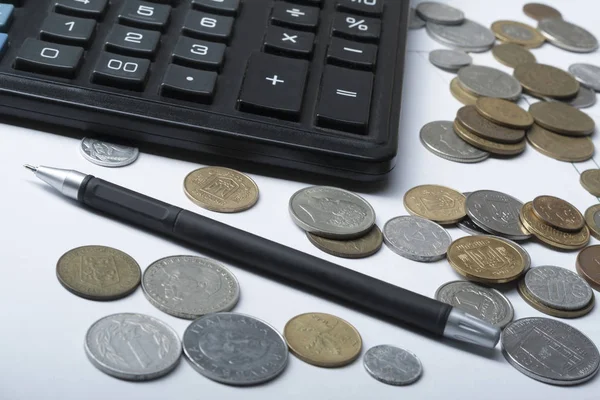 Strona główna oszczędności, koncepcja budżetu. Kalkulator, pióra i monety na office tabela — Zdjęcie stockowe