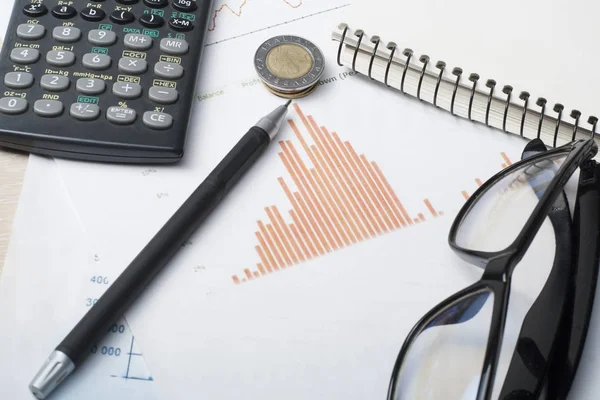 Ahorro en el hogar, concepto de presupuesto. Gráfico. pluma, calculadora y monedas en mesa de escritorio de oficina de madera — Foto de Stock