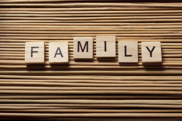 Word FAMILY written on wooden cubes at wooden background