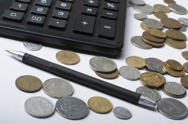 Ev tasarruf, bütçe kavramı. Hesap makinesi, kalem ve sikkeler üzerinde ofis masaları