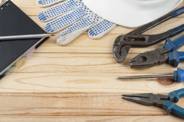 Kask, not defteri ve çalışma araçları, beyaz eldiven inşaat ahşap arka plan üzerinde. Metin için yer kopyalayın.