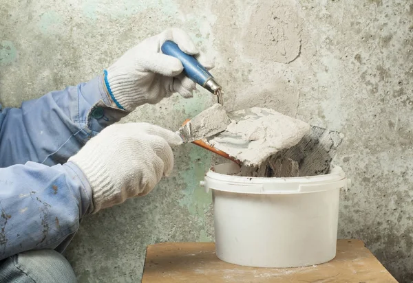 Concepto de construcción y renovación. Manos de trabajador en guantes con herramientas de enlucido . — Foto de Stock