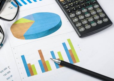 Ev tasarruf, bütçe kavramı. Grafik. kalem, hesap makinesi ve ahşap ofis resepsiyon masası gözlük