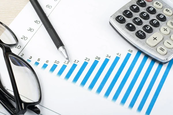 Binnenlandse besparingen, begroting concept. Grafiek, pen, rekenmachine en glazen op houten bureau tafel — Stockfoto