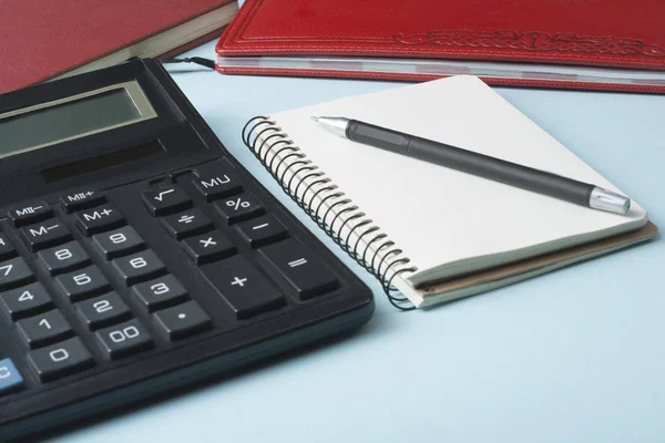 Ahorro en el hogar, concepto de presupuesto. Calculadora, bolígrafo y libros contables en la mesa de oficina — Foto de Stock