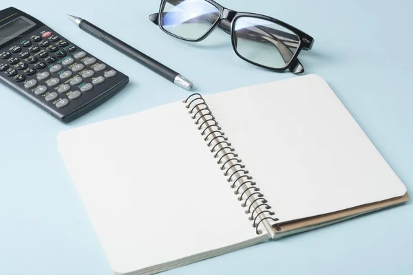 Home savings, budget concept. Calculator, pen, glasses and notepad on office table.