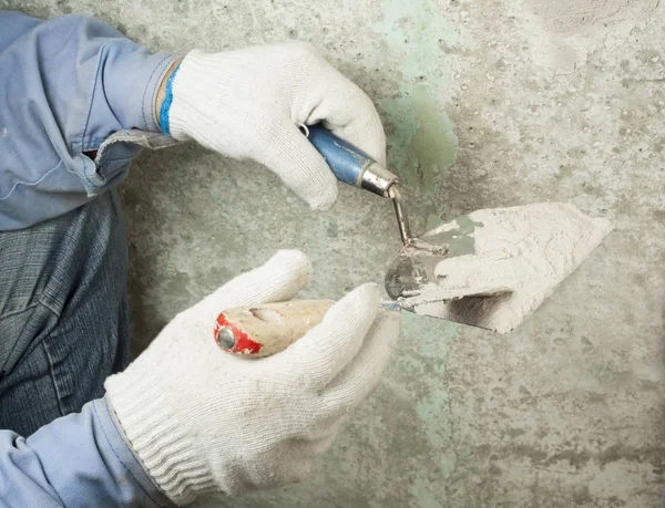 Concepto de construcción y renovación. Manos de trabajador en guantes con herramientas de enlucido . — Foto de Stock