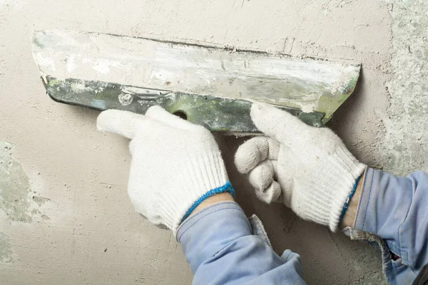 Conceito de construção e renovação. Mão de homem em luva com espátula durante o reparo de parede . — Fotografia de Stock