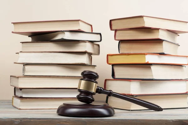 Концепція права. Книги з дерев'яним суддею давали на столі в залі суду або виконавчій службі . — стокове фото