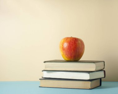 Kitaplar ve ahşap masa üzerinde elma yığını. Eğitim arka plan. Okula dönüş. Metin için yer kopyalayın.