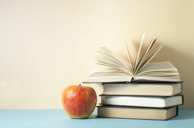 Açık kitap, ciltli kitaplar ve ahşap masa üzerinde elma. Eğitim arka plan. Okula dönüş. Metin için yer kopyalayın.