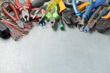 Metalik arka plan üzerinde elektrik araçlar kümesi. Mühendislik çalışmaları, enerji kavramı için aksesuarlar. Metin için yer kopyalayın.