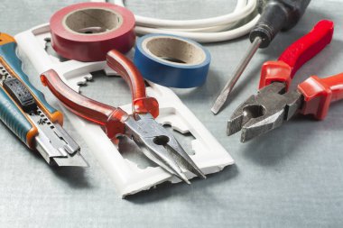 Metalik arka plan üzerinde elektrik araçlar kümesi. Enerji kavramı.